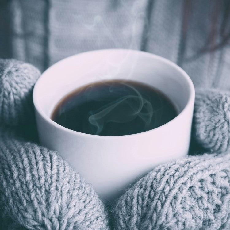gloved hands holding coffee
