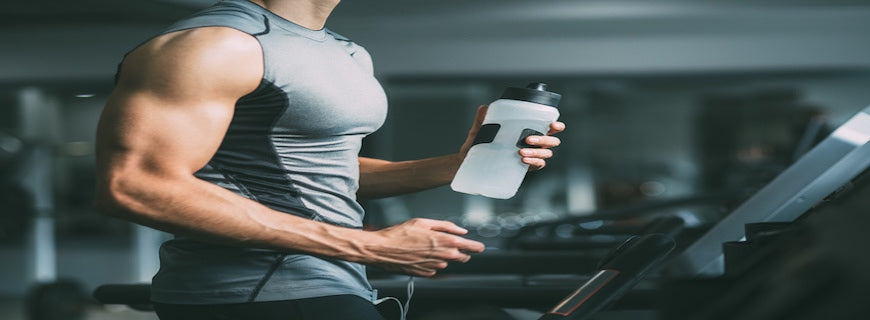 Male gym user holding water bottle