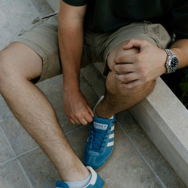 person sitting down holding knee