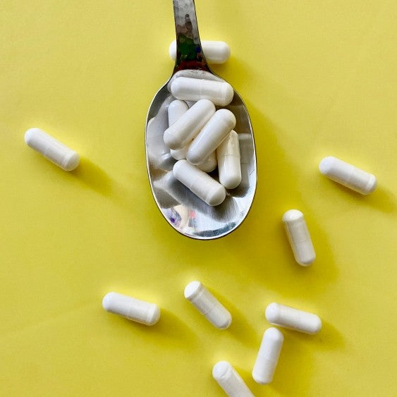 spoon with white capsules on it