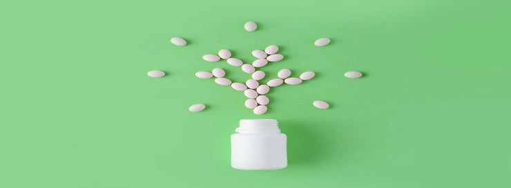 White pills in shape of tree on green background