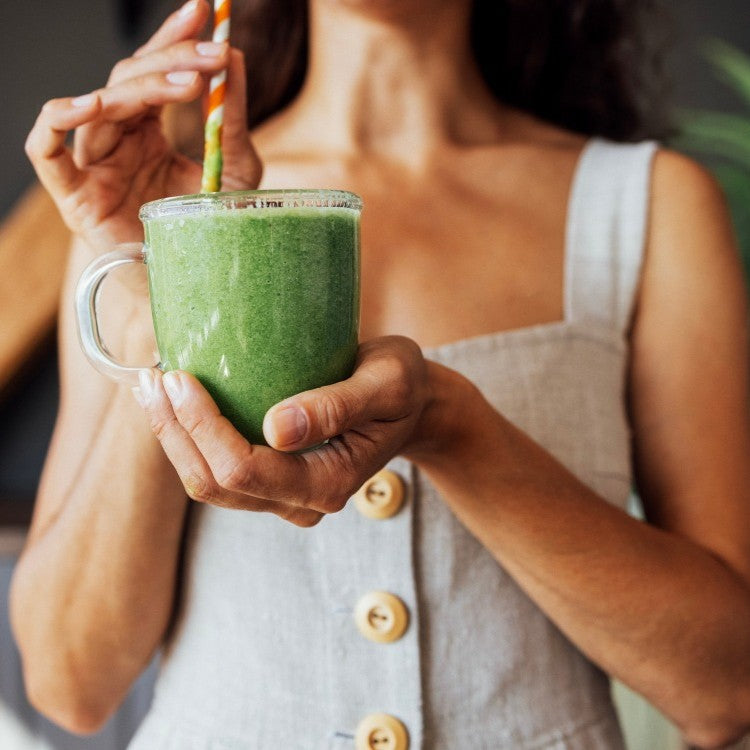 woman holding green drink