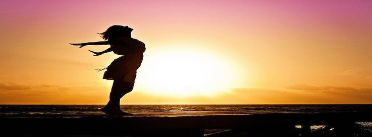 silhouetted woman stretching in sun