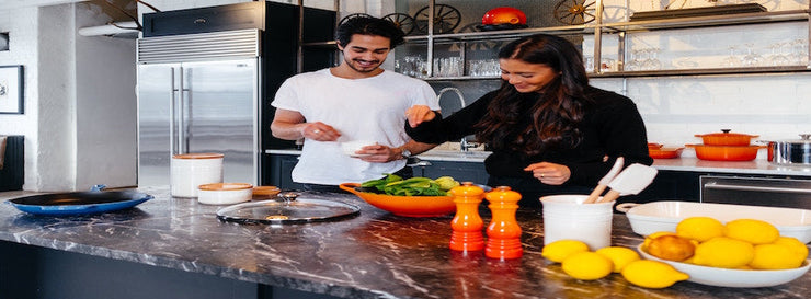 twentysomething man and woman cooking healthy food in kitchen