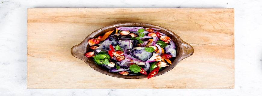 a colourful salad bowl on a wooden chopping board