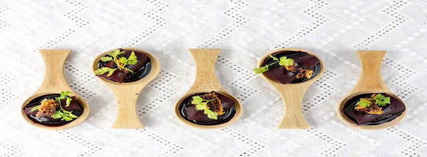 five wooden spoons containing chunks of beetroot