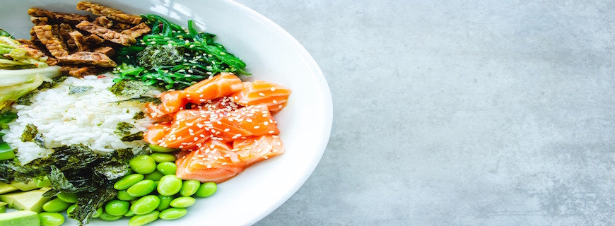 Healthy plate containing salmon, greens, soy beans and more