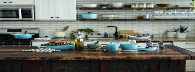 kitchen countertop featuring bottle of olive oil, various crockery