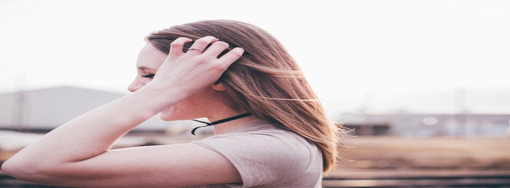 blonde woman clutching her own hair in gesture of anxiety