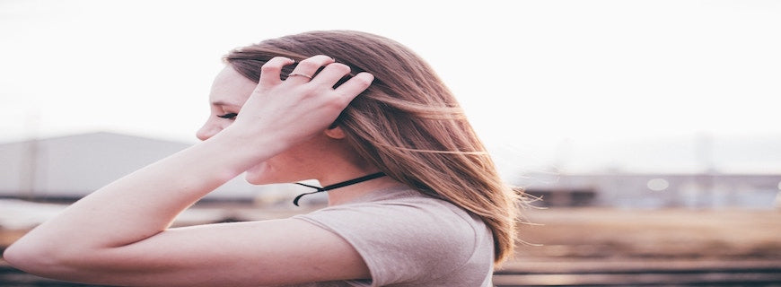 blonde woman clutching her own hair in gesture of anxiety