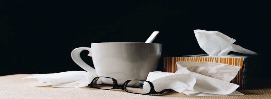 cup sitting alongside tissues and glasses