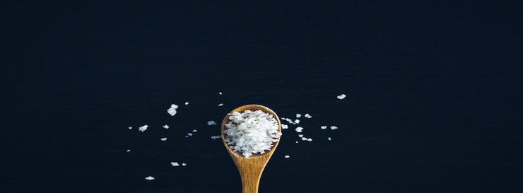 image of wooden spoon containing salt flakes