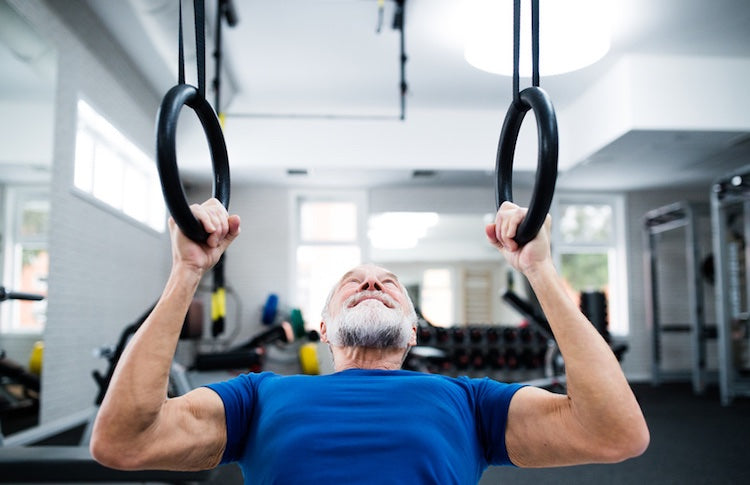 Elderly man working out on gymnastic rings