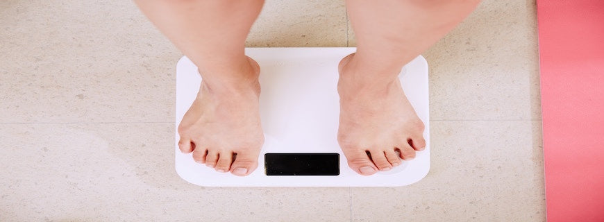 person's feet on weighing scales