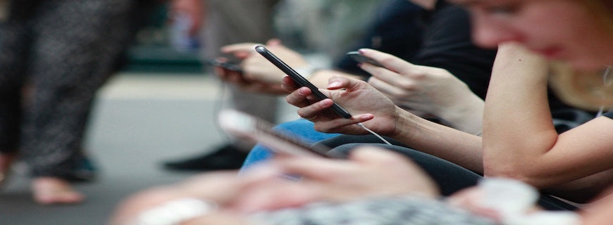 sidelong photo of various people glued to their smartphones