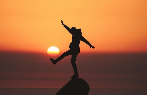 Person on rock in sunset