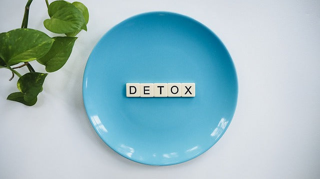 scrabble letters on blue plate spelling detox