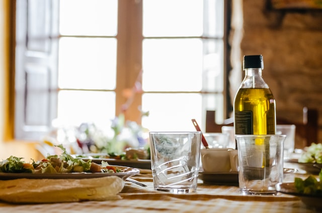 Salad and bottle of olive oil on table