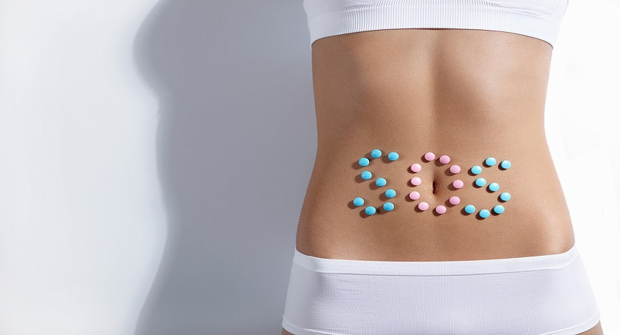 bare stomach with SOS spelled out in pills