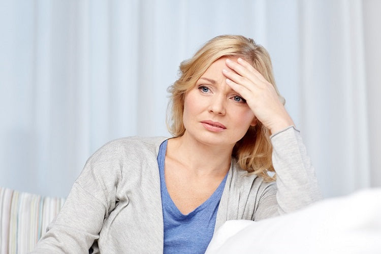 woman holding hand against forehead