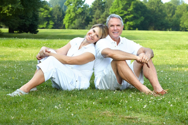 man and woman sitting on grass