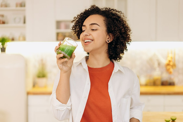 woman drinking green drink