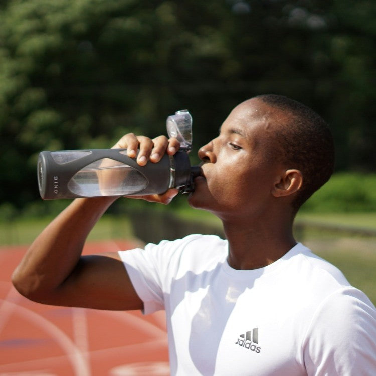 Man outdoors drinking water from bottle