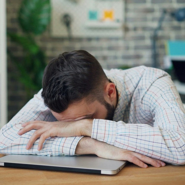 man slumped over laptop