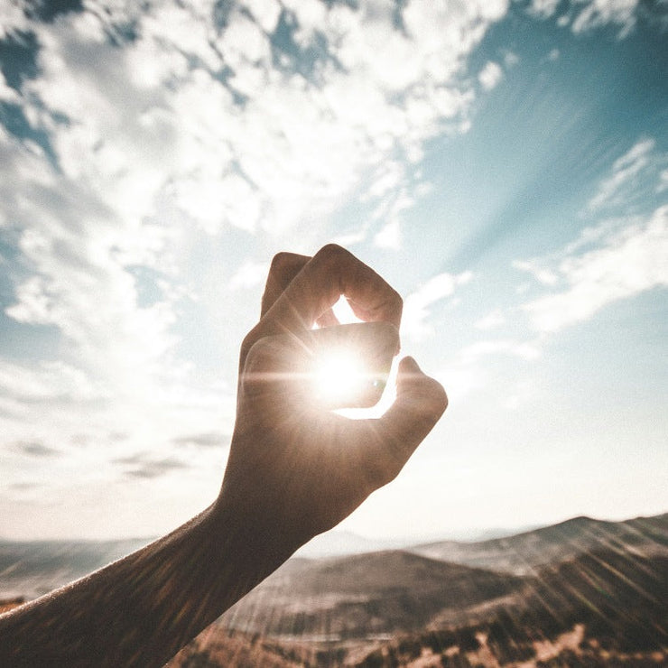hand with sun behind