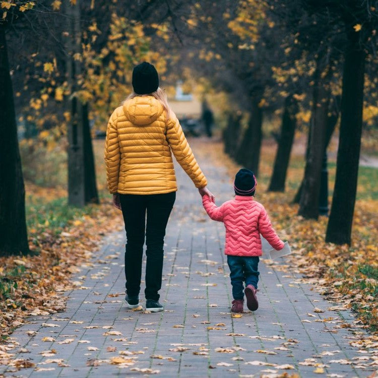adult and child walking in park