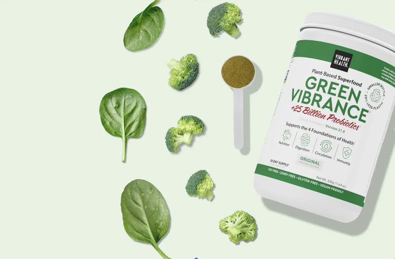 tub of green vibrance with scoopful of powder broccolli and spinach leaves