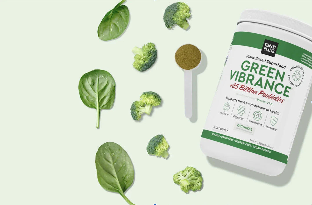 tub of green vibrance with scoopful of powder broccolli and spinach leaves